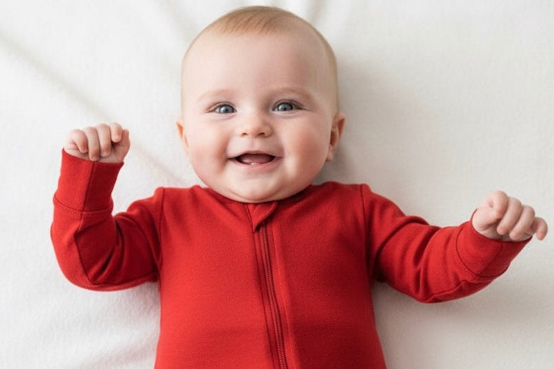 Baby wearing a red onesie on a white background